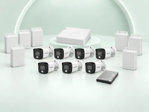 7 Hikvision DS-2CE16D0T-EXLPF cameras, DS-7108HGHI-M1/T DVR, 500GB HDD and 7 power supplies on a light mint studio background